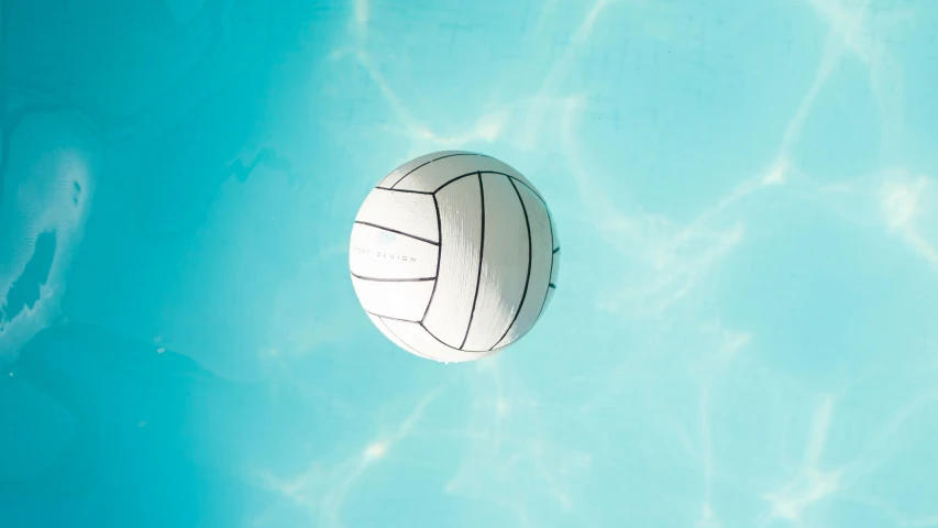 a volley ball in the water above a swimming pool