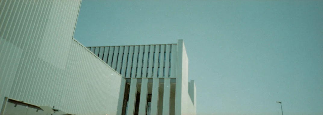 a tall white building with vertical lines in the front