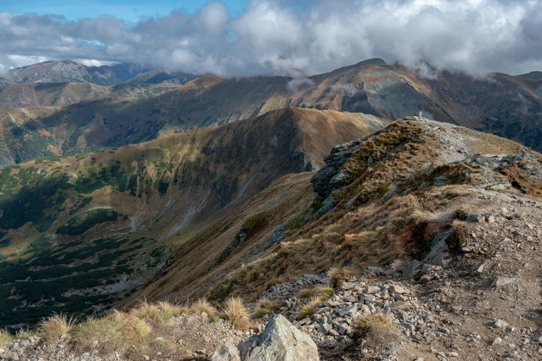 clouds are coming over a mountain range in the mountains