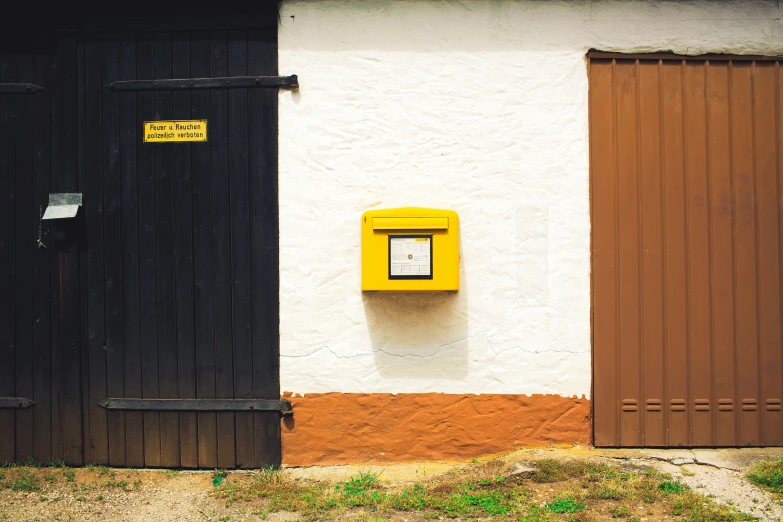 a yellow phone box next to two doors