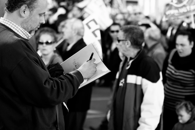 man in black jacket speaking to people in the street