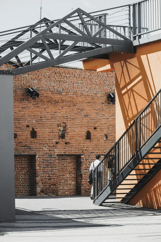 an outdoor staircase with a black steel railing next to a brick building