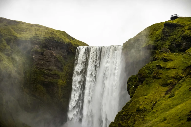 a large waterfall that is in the middle of some grass