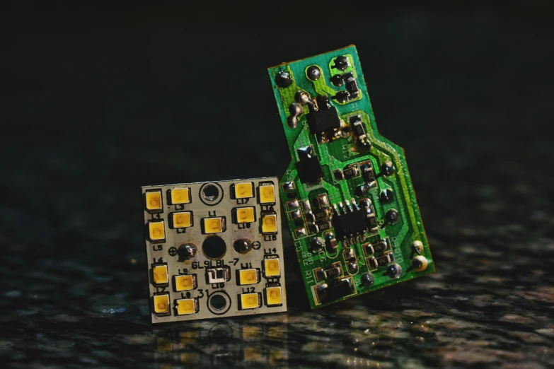 an electronic circuit board laying beside a printed circuit board