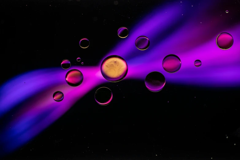 colorful droplets floating and spinning in a dark sky