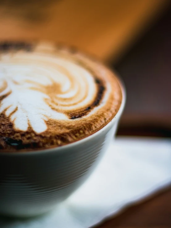 an elaborate latte sitting on a table with white designs