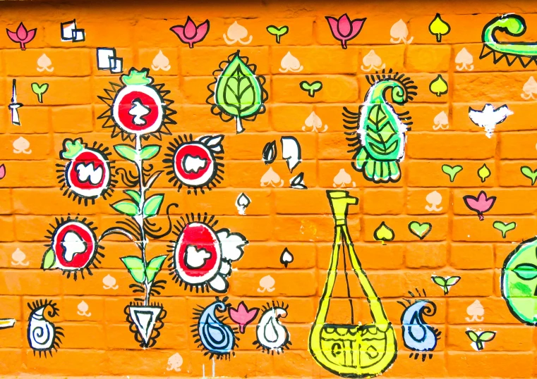 a brick wall with flowers, birds, and plants painted on it