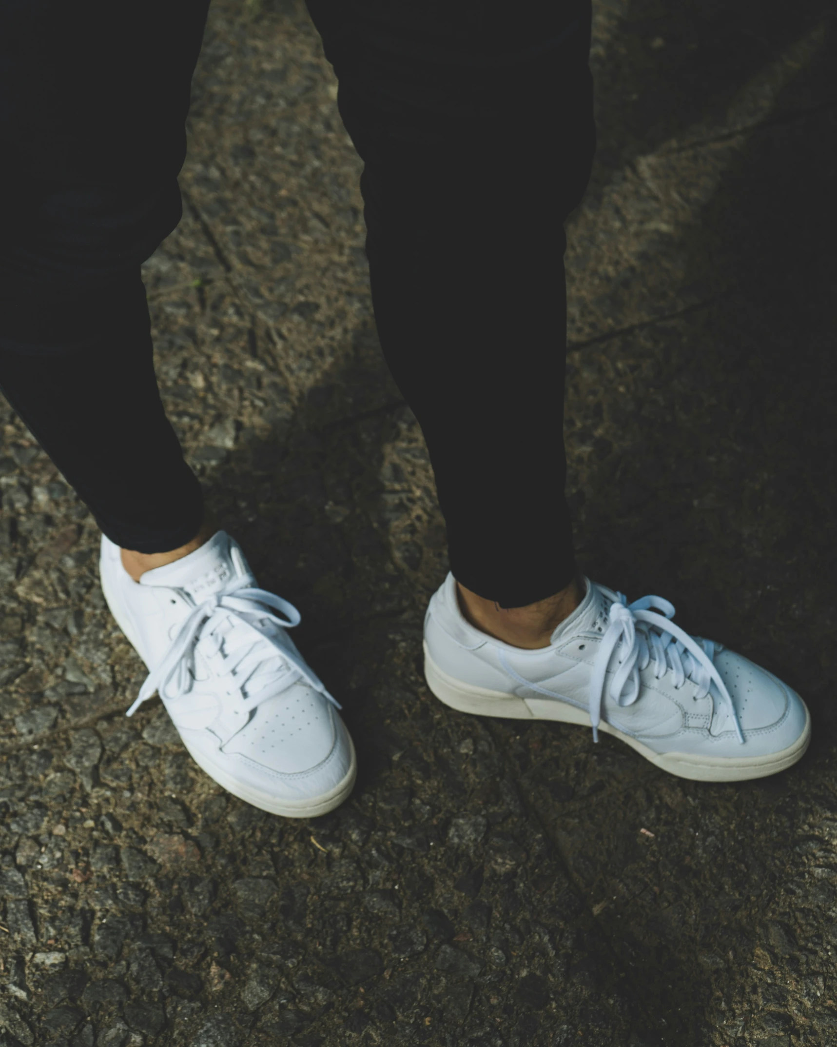 a woman in white tennis shoes with her legs crossed