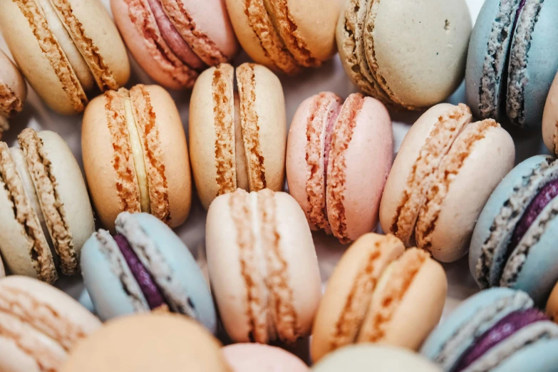 a group of different color macaroons in rows