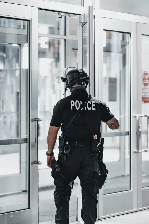 a police officer in uniform is standing outside a doorway