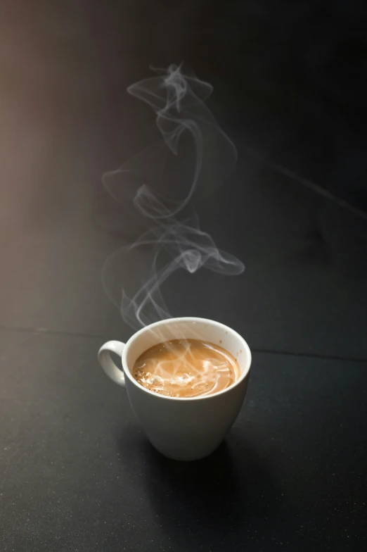 a white coffee cup filled with liquid and steam