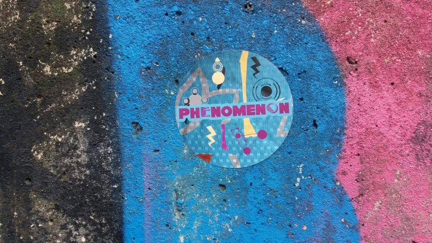 a blue and pink painted board on a sidewalk