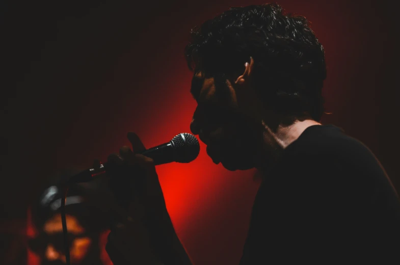 a close - up of a young man wearing headphones while singing