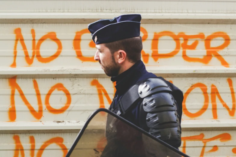 a man in black jacket next to a white building