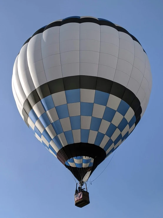 a large white and blue balloon floating in the sky