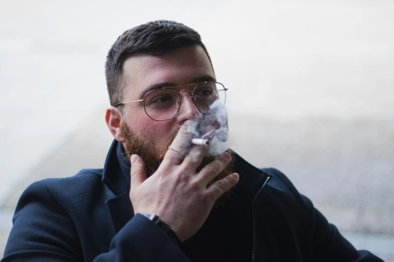 a person with glasses smoking an electronic cigarette