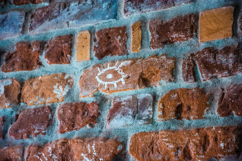 a brick wall has white stencils on it