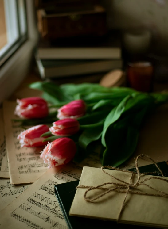 a group of pink tulips sitting on top of a wooden table