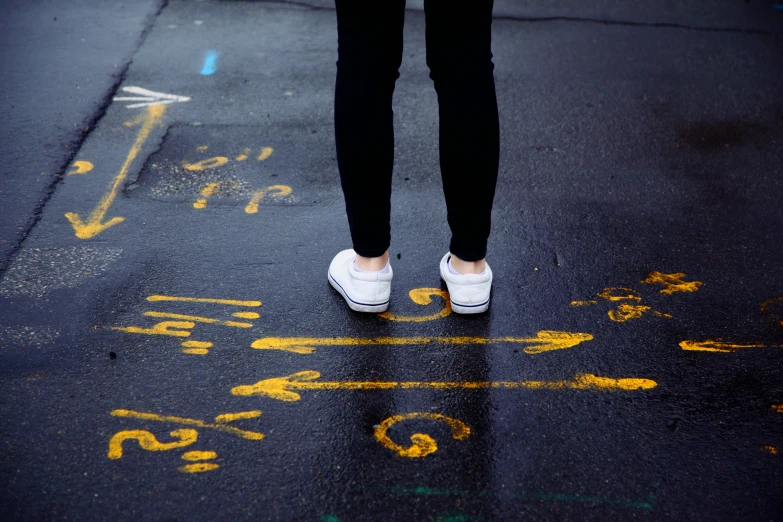 a person standing in the middle of the road with yellow lines painted on the ground