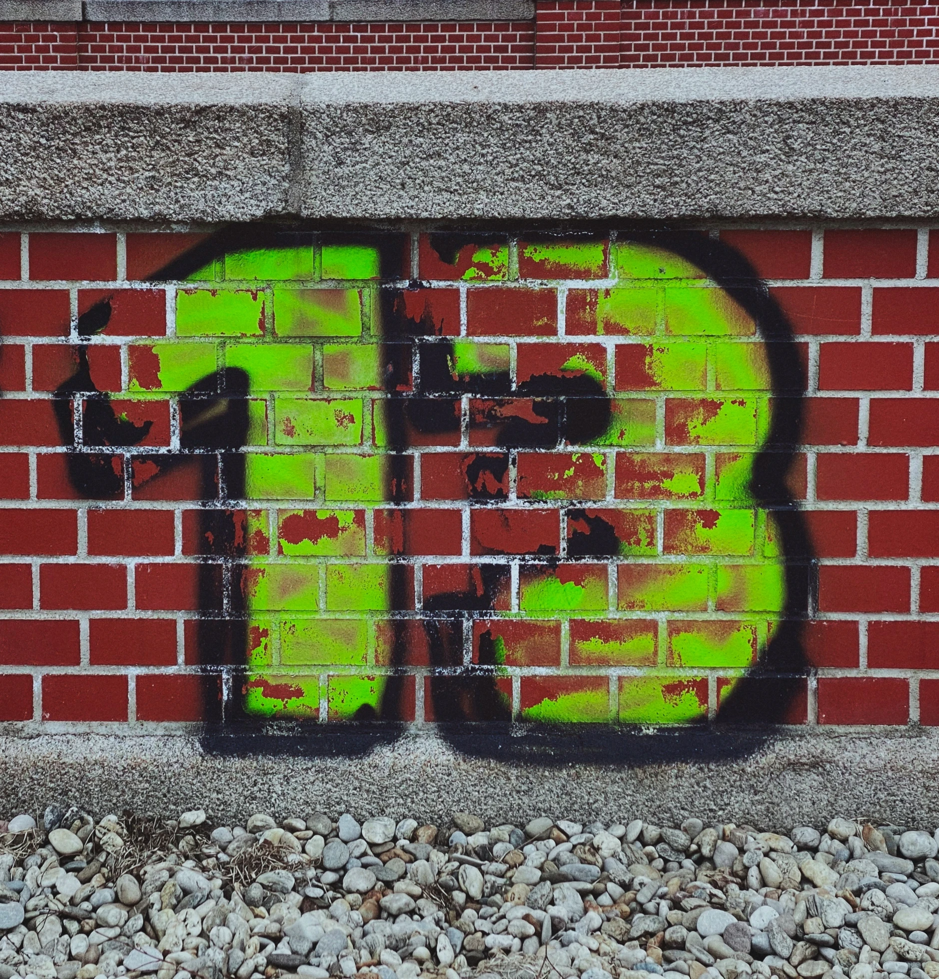 graffiti painted on a brick wall with a black and white cat