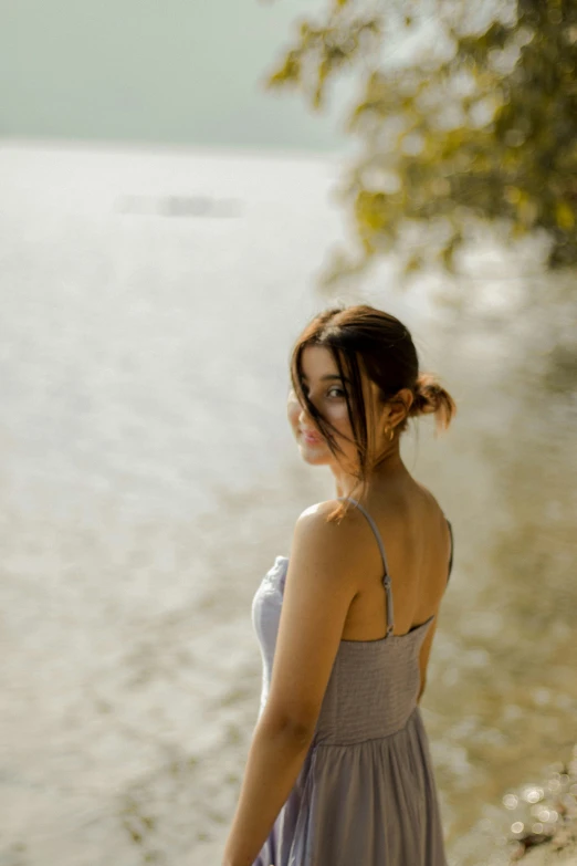 a person standing next to a lake with a surfboard in their hand