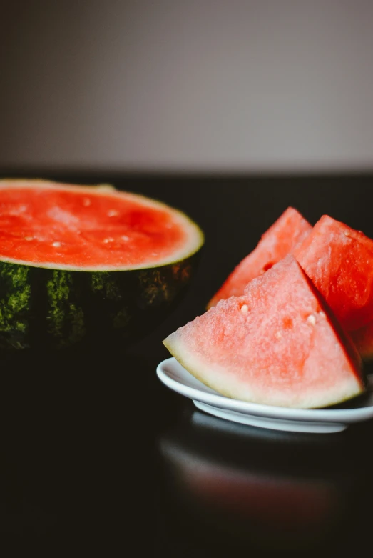 a piece of watermelon that is on a white plate