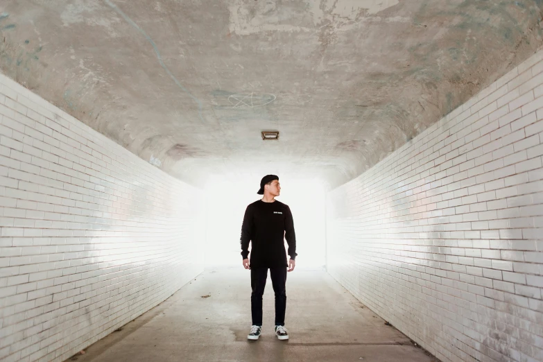 a man standing alone in a long tunnel