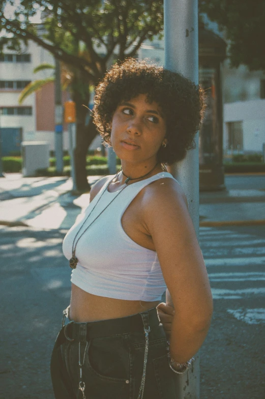 woman in white top standing on street corner