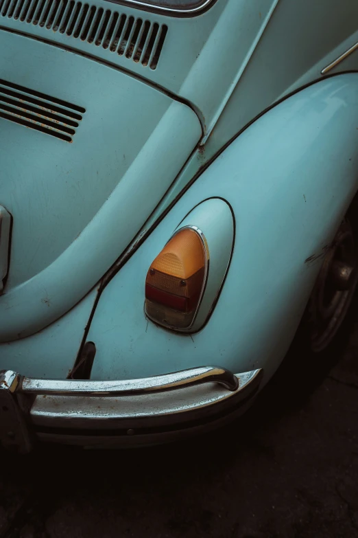 the front bumper of an old beetle parked on a street