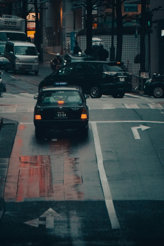 a taxi cab stopped at an intersection in the rain