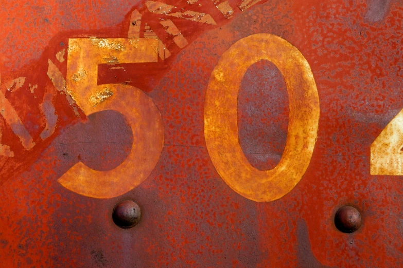 a close up view of a rusty sign with the word o and yellow numbers