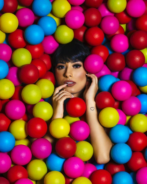 a woman sitting in a colorful ball pit