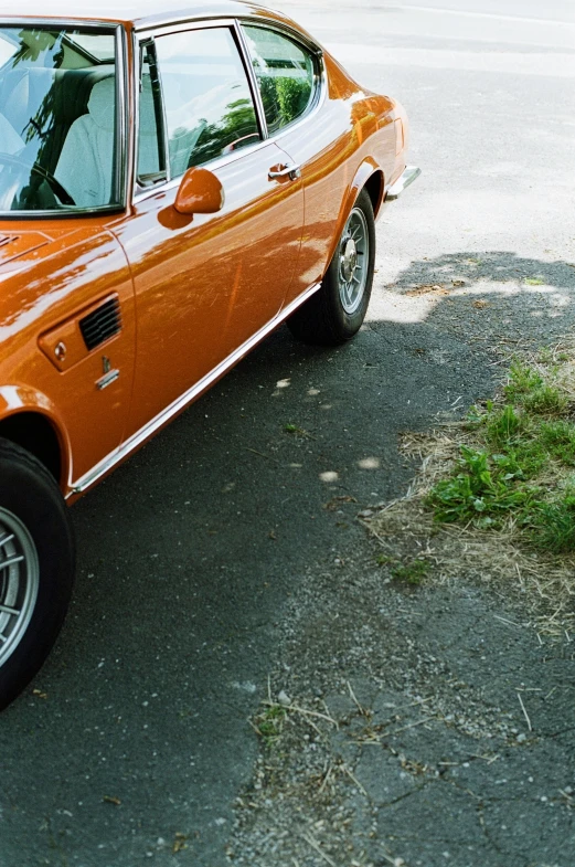 an orange sport car parked on a paved street