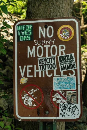 a brown and white sign with some stickers on it