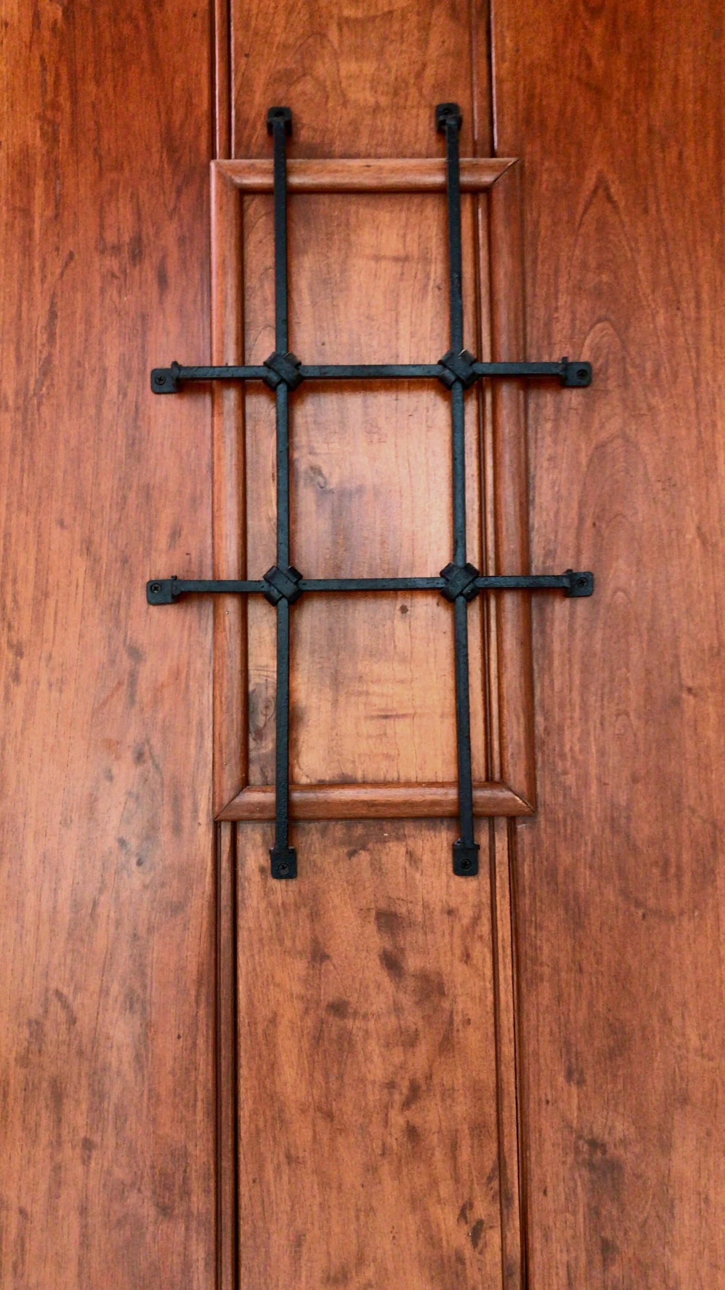 an old wooden door has a metal cross on it