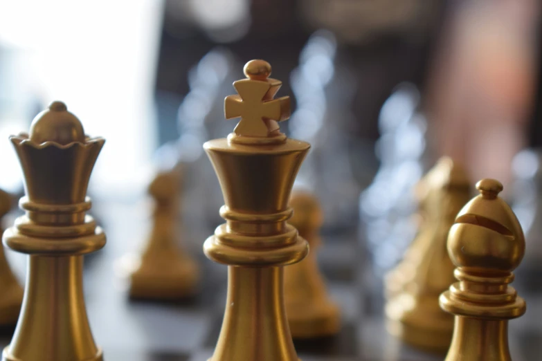 a chess set made out of gold is on a black board