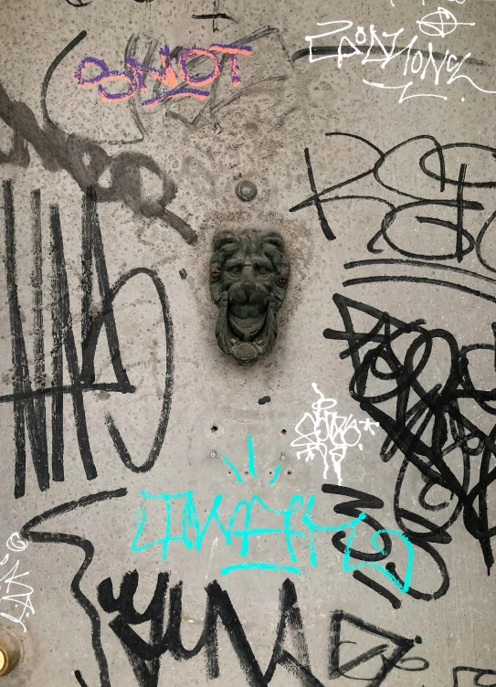 the sidewalk has graffiti on it and a face shaped in a mask