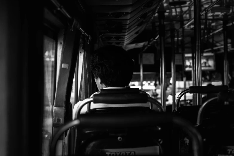 two people on the bus and one has his back turned toward the camera