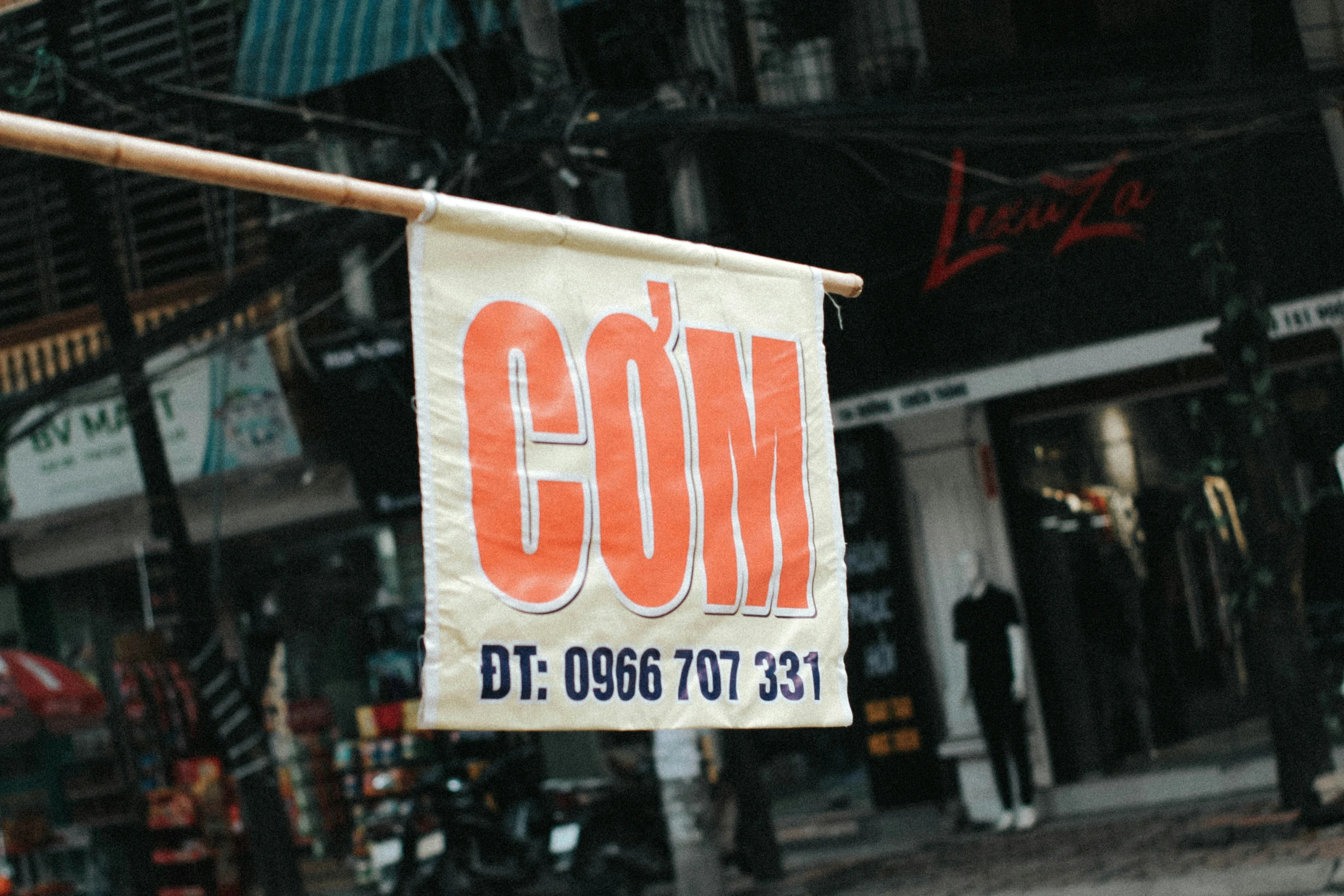 a white sign hanging from a metal pole