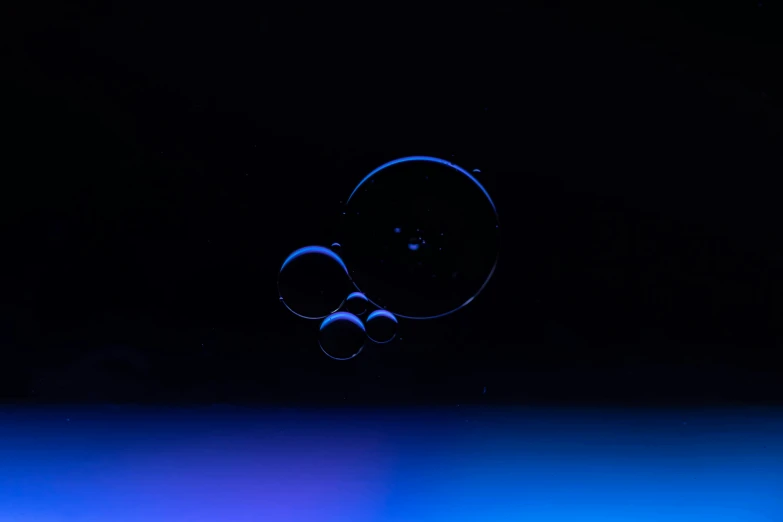 two bubbles are floating down a blue black background