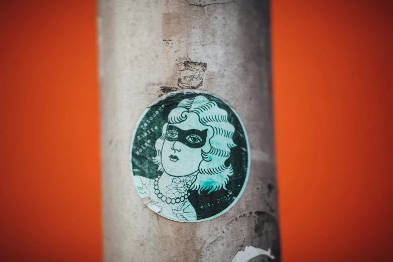 a sticker on a post showing a woman wearing mask and eyeglasses