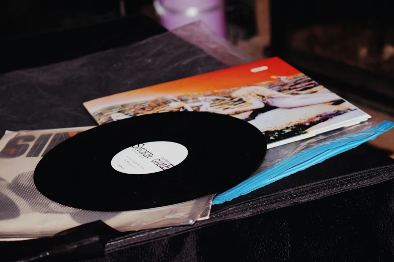 a black record sitting on top of an opened newspaper