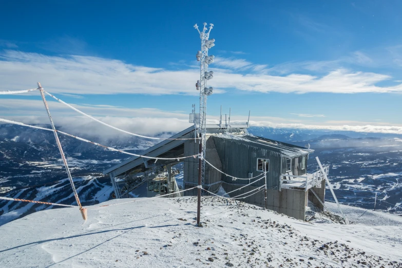 an old building on the top of a mountain covered in snow