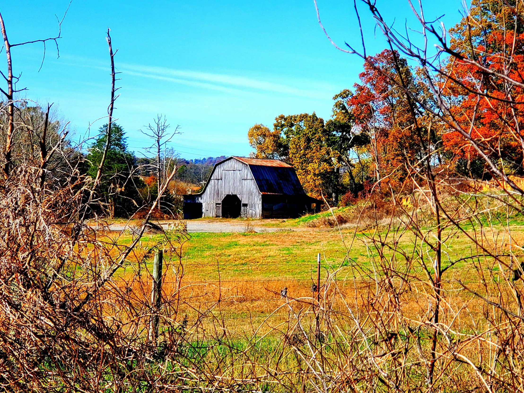 there is a barn sitting in the middle of the field