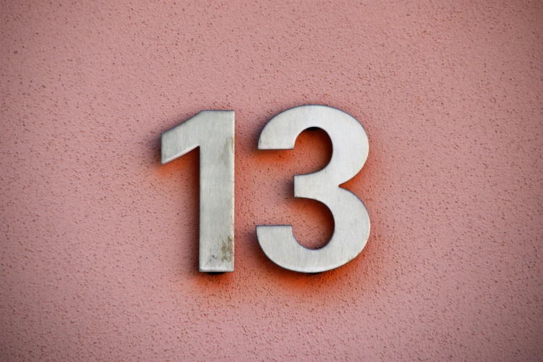 a metal sign with the number thirteen on it