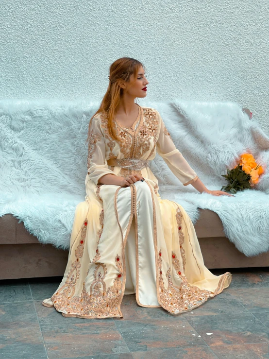 woman sitting on the floor, wearing a white and beige outfit