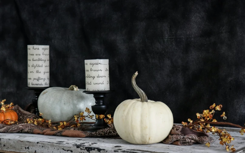 several small pumpkins and candles on a shelf