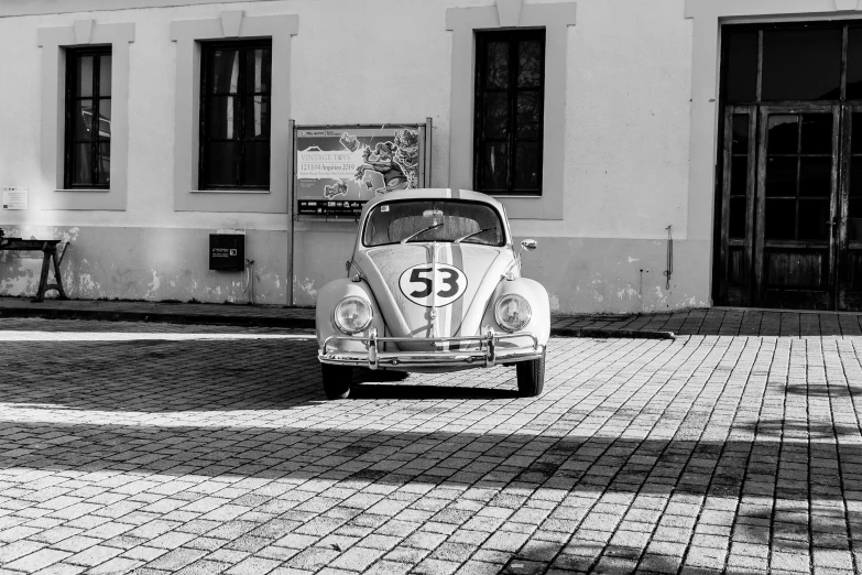 an old beetle car sits on a paved street