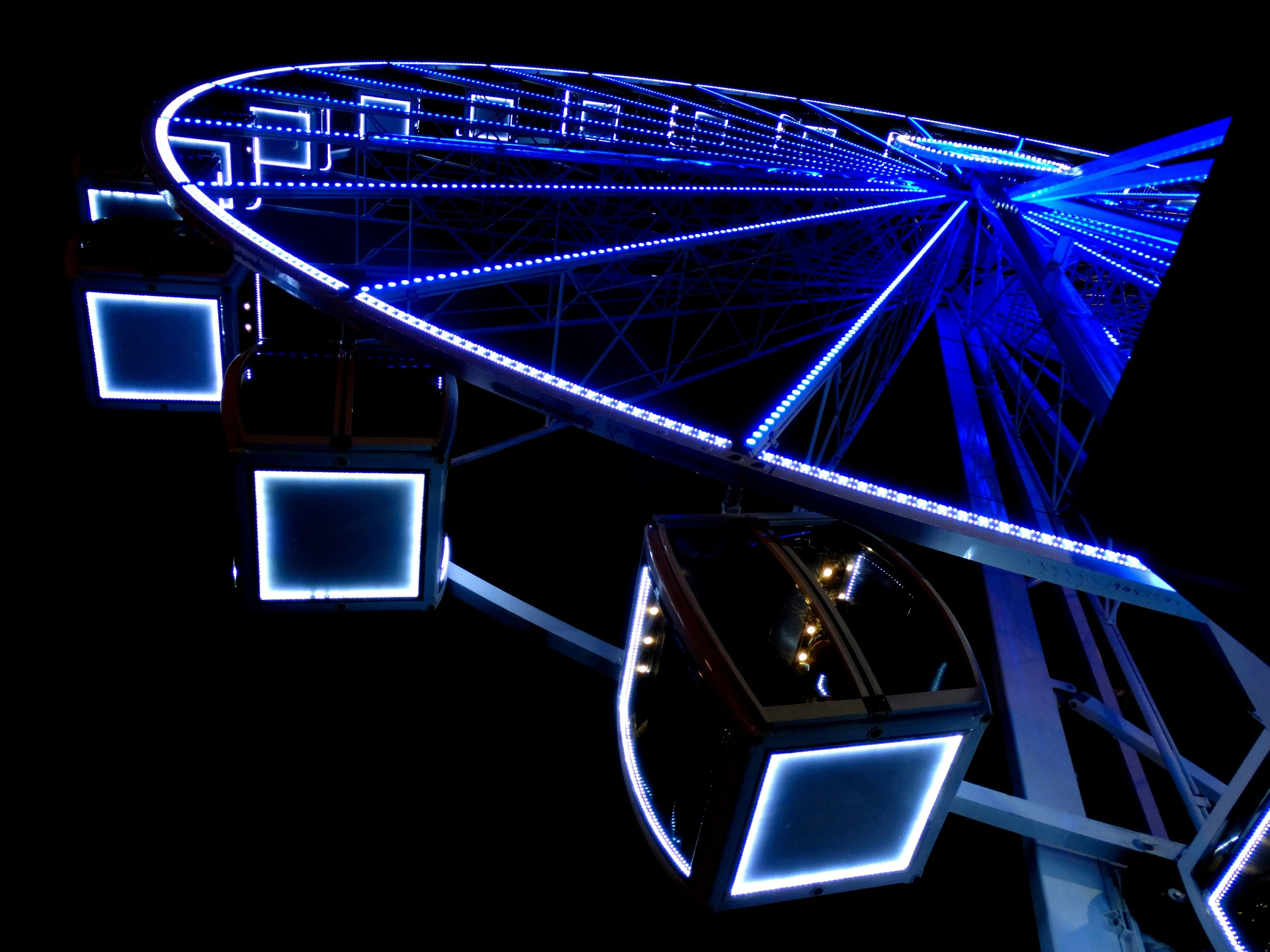 the ferris wheel is blue at night