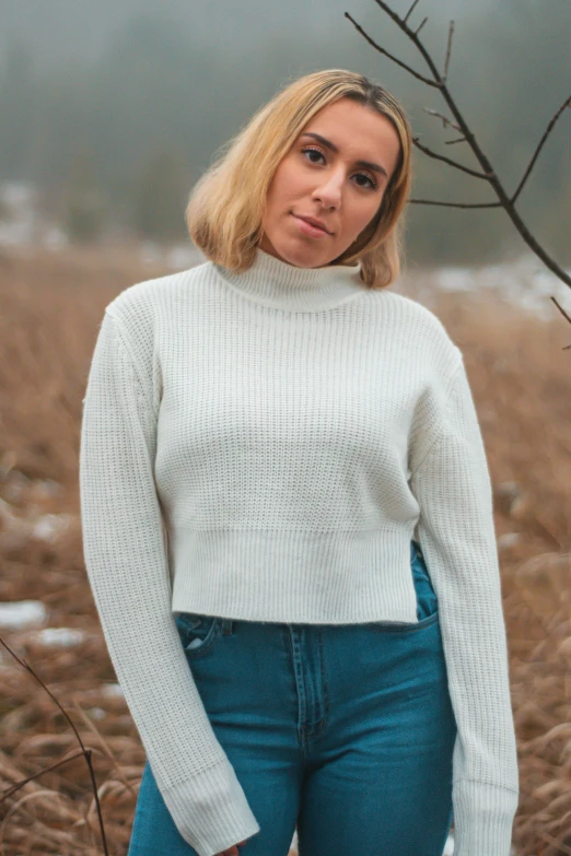 a blonde woman is posing for the camera with snow on the ground in front of her